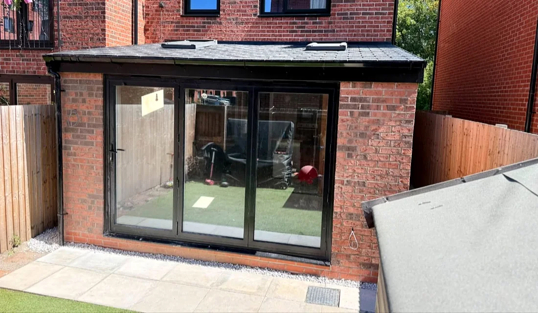 The extension straight on, doors closed, patio in front