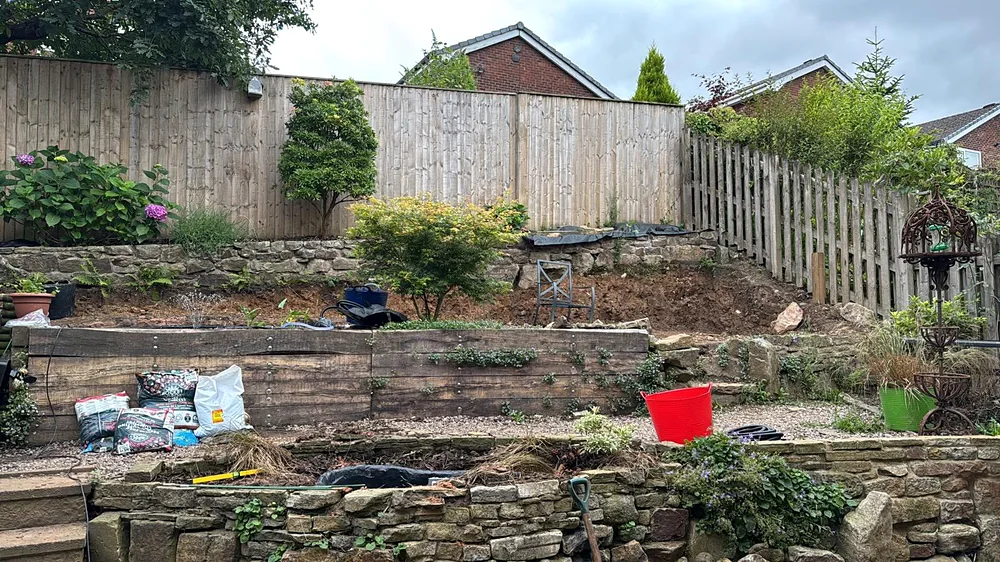 The sloping garden with its old stone walls at the start of the job